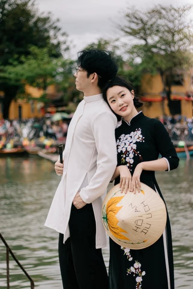 ホイアンで伝統的なアオザイを着て写真撮影